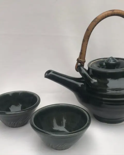 Green teapot with cane handle and cups